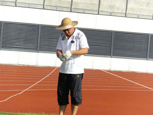 实拍深圳宝安体育馆足球场景观，有工人在维护有市民在跑步