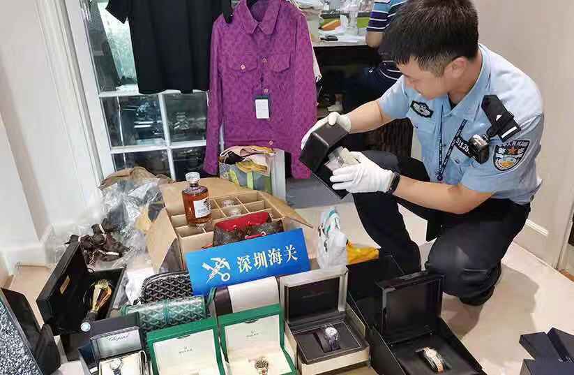 女子拿六个旅行箱过海关,一女子拿着行李箱