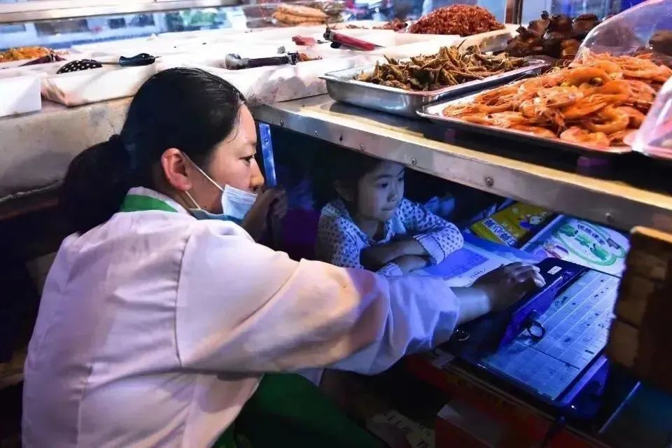 7岁女童案板下学习一个月走红,湖北7岁女孩躲菜市场案板下上课