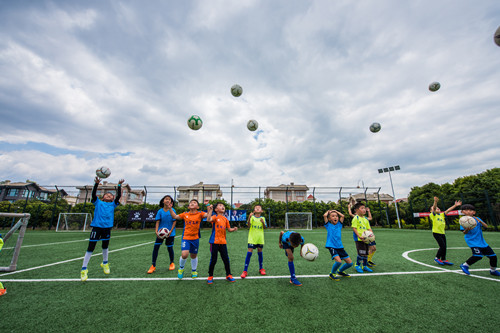 开学上学校踢球,春天到了小朋友们在草地上踢足球