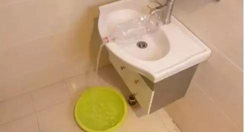 把塑料瓶套在水龙头上,塑料瓶剪下瓶盖套米袋口