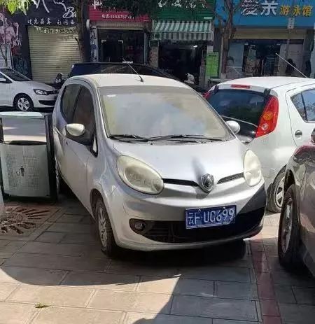 肩上挑着担子，脚下骑着电动车，晃晃悠悠的沿街叫卖，差点擦到车！