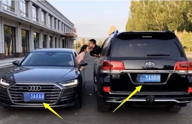 年轻小夫妻秀恩爱，车牌都是情侣号，身后车标是亮点
